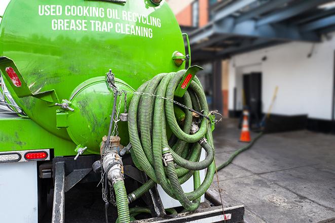 a grease trap being pumped by a sanitation technician in Penfield NY